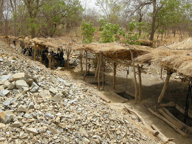 Makeshift shelters cover shafts dug by hand along a vein by artisanal miners in Senegal.  Rhys.