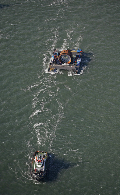 Tugboats pull a barge containing the OpenHydro turbine into position near Parrsboro, Nova Scotia, in November 2009. 