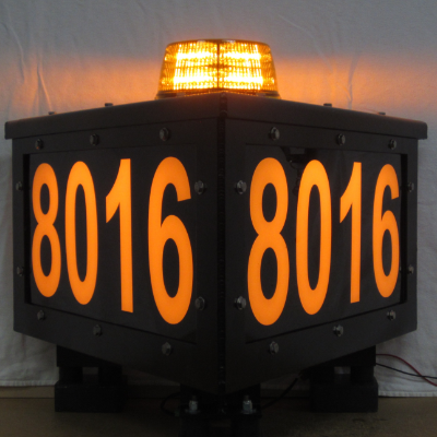 A lit-up, three-sided sign with a light on top and the numbers 8016 on the side.