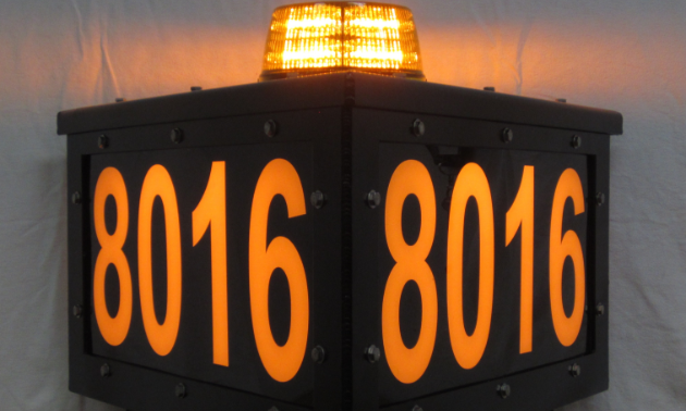 A lit-up, three-sided sign with a light on top and the numbers 8016 on the side.