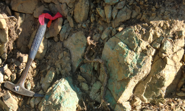 A tool rests next to a rock of minerals