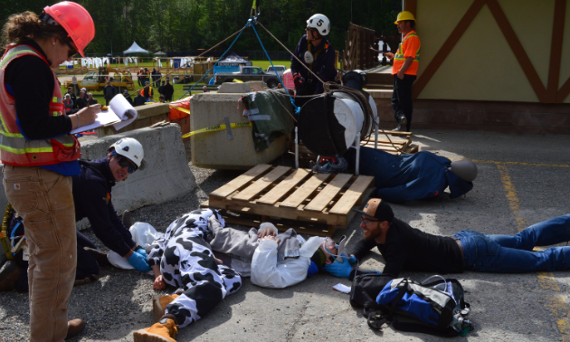 Mine rescue workers try to free a man trapped under a woman dressed in a cow costume