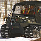 an all-terrain vehicle on tracks carrying workers over snow