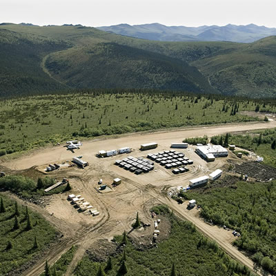 Aerial view of the Casino Project in Canada's Yukon Territory, showing camp and roads surrounded by trees and distant mountains. 