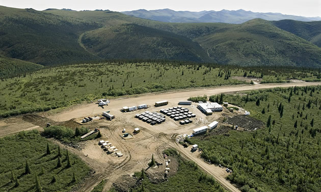 Aerial view of the Casino Project in Canada's Yukon Territory, showing camp and roads surrounded by trees and distant mountains. 