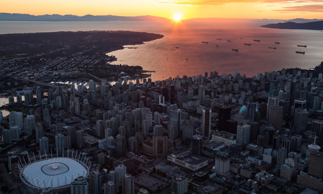 Scenic view of downtown Vancouver, with sun setting in distance. 
