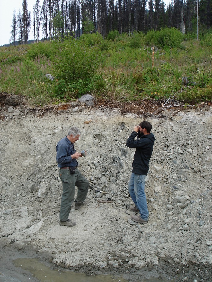 Photo of two men looking at a rock