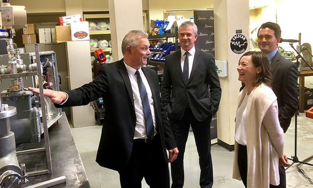 Henri Tessier gives Minister Phillips, Steve MacDonald, and Jackson Hegland a tour of his business’ workshop.