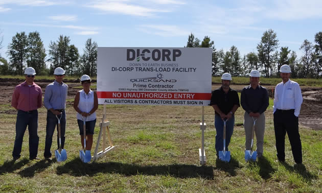 Di-Corp employees standing by company sign