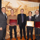 a group of people standing together with an award certificate