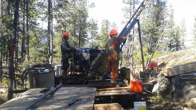 Picture of two men using drilling equipment. 