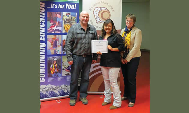 College of the Rockies Haul Truck Operator program graduate, Meagan Sam, receives her certificate of completion from instructor Darren Hood and AMTA Program Manager Suzanne Pederson. Meagan was one of six women who completed the first all-female class.