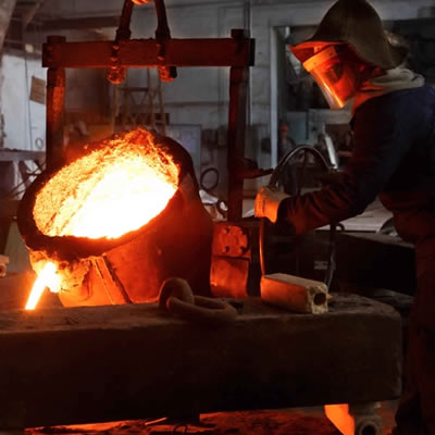 Worker pouring molten gold. 