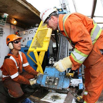 Two workers at a drilling station. 