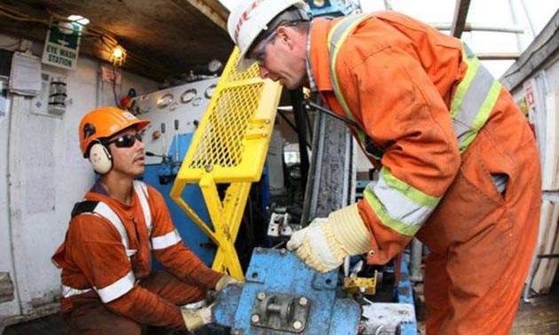 Two workers at a drilling station. 