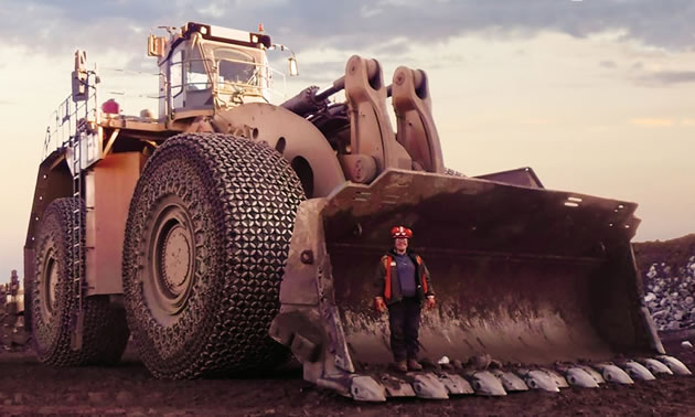 Large piece of machinery with person standing in bucket. 