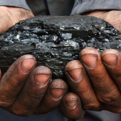 A man holding come raw coal