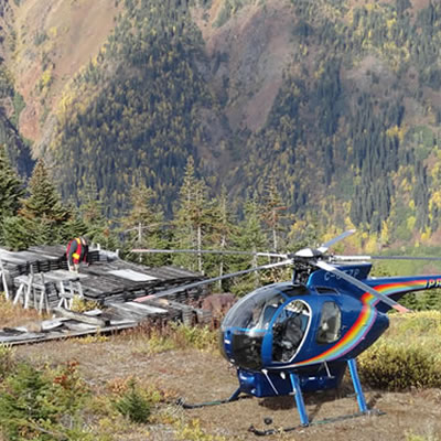 Picture of helicopter at a forested landing area. 