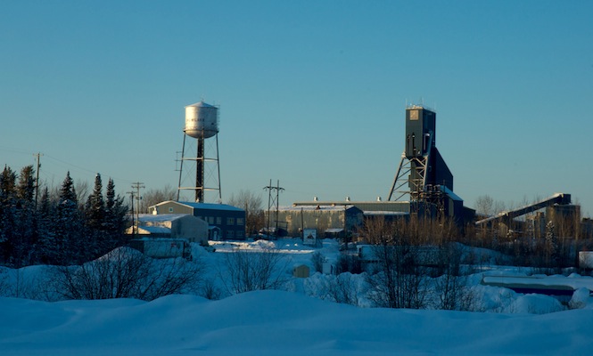 Several buildings and towers set at a mine site with snow on the ground