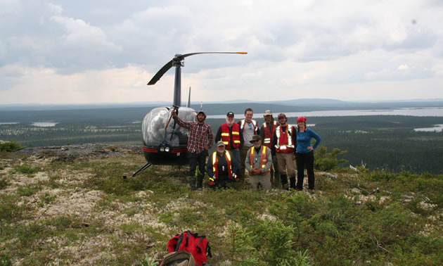 Stelmine Canada group shot, standing in front of a helicopter. 