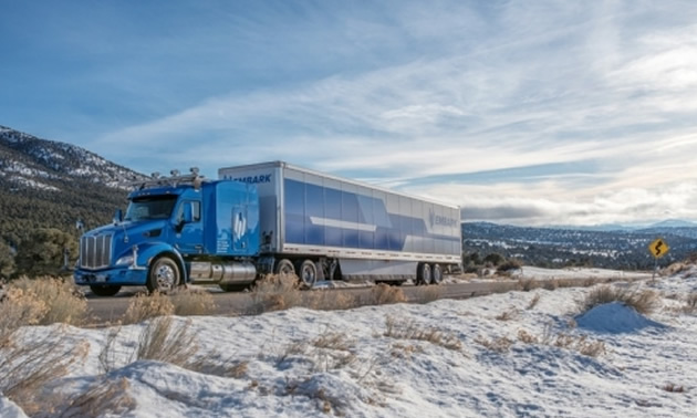 A long-haul truck on a snowy day. 