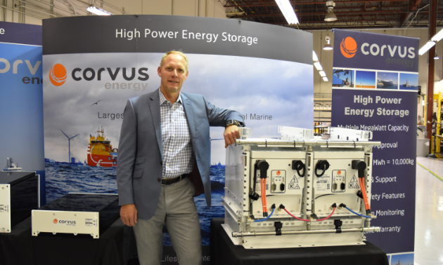 Andrew Morden, CEO of Corvus Energy stands beside a bank of their heavy-duty industrial batteries capable of powering large ferries and other marine vessels.