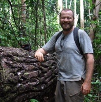 Andy Randell leaning on a log in the Guyanian forest.