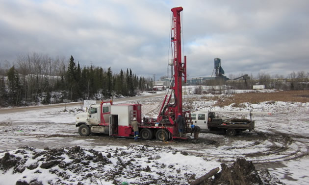 A large mining drill situated on a snowy field 