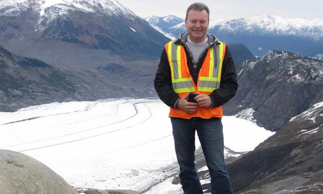 Bill Robertson is standing on a mountain and checking structure locations prior to construction at the Brucejack Gold Mine.             