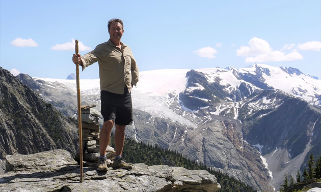 Bruce Madu is standing on a rocky mountaintop with a walking stick near Roger’s Pass along the Trans-Canada Highway west of Field, B.C.