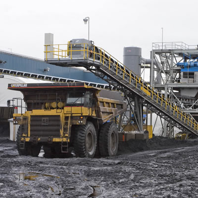 Picture of Brule Mine in operation, with a mining truck being loaded via conveyor belt. 