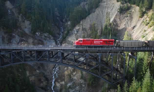 A CP Rail train travelling over a bridge. 