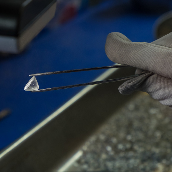 A large diamond is being held in tweezers.