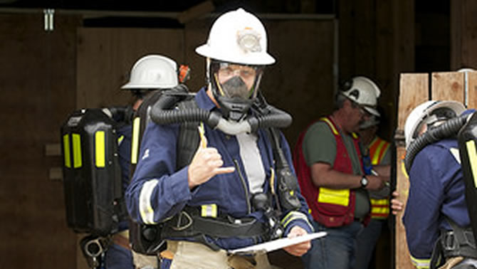Fireman wearing respirator and making the 'thumbs up' sign