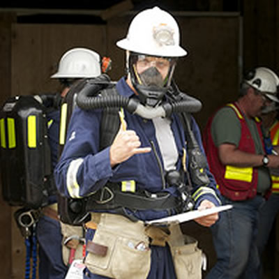 Fireman wearing respirator and making the 'thumbs up' sign