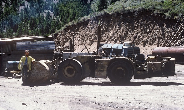 Lamarre stands beside a mucking machine, an underground mining vehicle for hauling ore, at the entrance to the Thompson Creek molybdenum mine near Challis, Idaho, in 1976. 