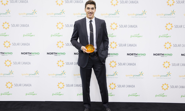 Alexander Palkovsky is holding his award from the Canadian Solar Industries Association.