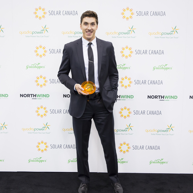 Alexander Palkovsky is holding his award from the Canadian Solar Industries Association.