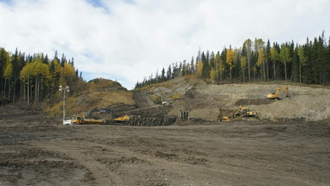 Picture of mining equipment and trucks in an open field. 