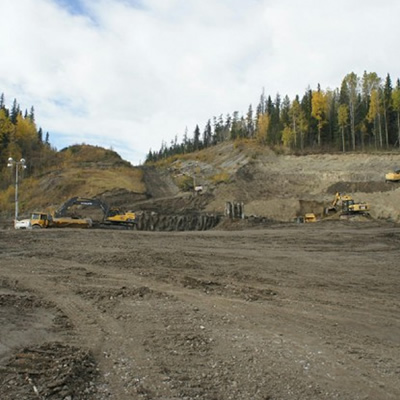 Picture of mining equipment and trucks in an open field. 