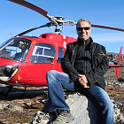 Man stands beside a helicoptor