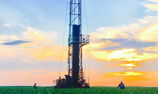 Picture of oil well silhouetted in sunset. 