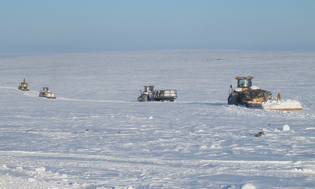 Here, CH-6 kimberlite is being hauled from CH-6 Camp to Iqaluit on April 16, 2013. In the convoy are four Cat Challenger tractors: the first is hauling the excavator, the next two are carrying samples and the fourth is transporting blast mats and pulling a trail groomer.