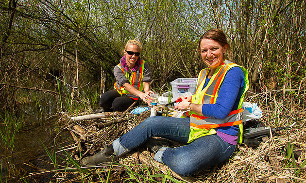 Biologist Elizabeth Vincer on the left with environmental specialist Lori Leach on the right working together in the field.