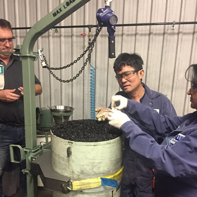 The Roben Jig cleans sample coal without the use of harmful chemicals. Here, several workers look at a coal sample in the Roben Jig.