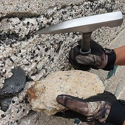 Picture of person holding rock hammer. 