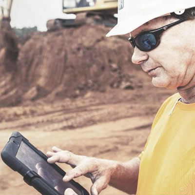 Picture of construction working using iPad on construction site. 