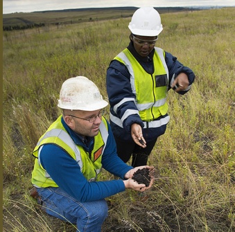 Anglo American Thermal Coal - Environmental - Kleinkopjie Colliery . Gustav Le Roux, rehab planner, and Dolly Mthethwa, environmental co-ordinator, inspect the results of the Fungcoal trials on the Klipan discard dump where a bacteria has been introduced to reduce the rough discard into viable organic material in which plants will grow. 