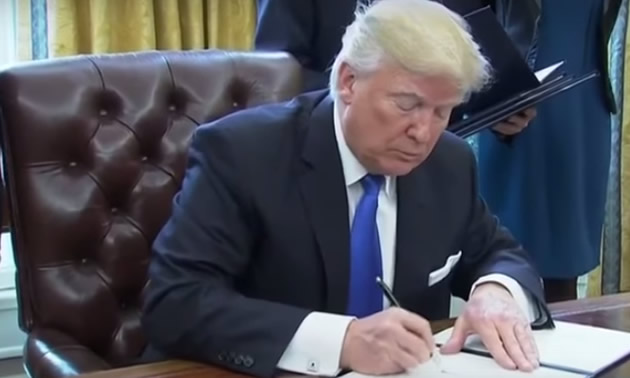 U.S. President Donald Trump signs an executive order, approving the Keystone XL and Dakota Access pipeline projects. 