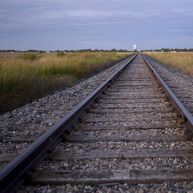 A photo of a railway track running off into the prairies.